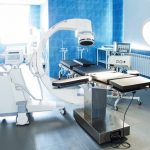 Horizontal_view_of_modern_operating_room_with_X-ray_medical_scan,_equipment_and_medical_devices._Bright_back_light.